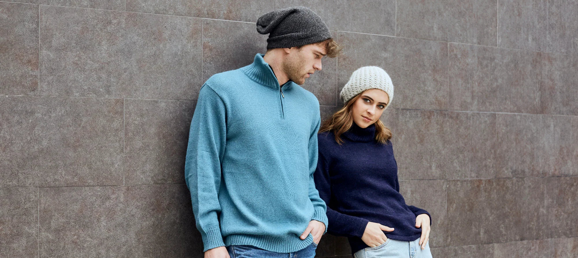 Man in a blue knit sweater and woman in a navy knit sweater with beanies, NORGÄTE knitwear style